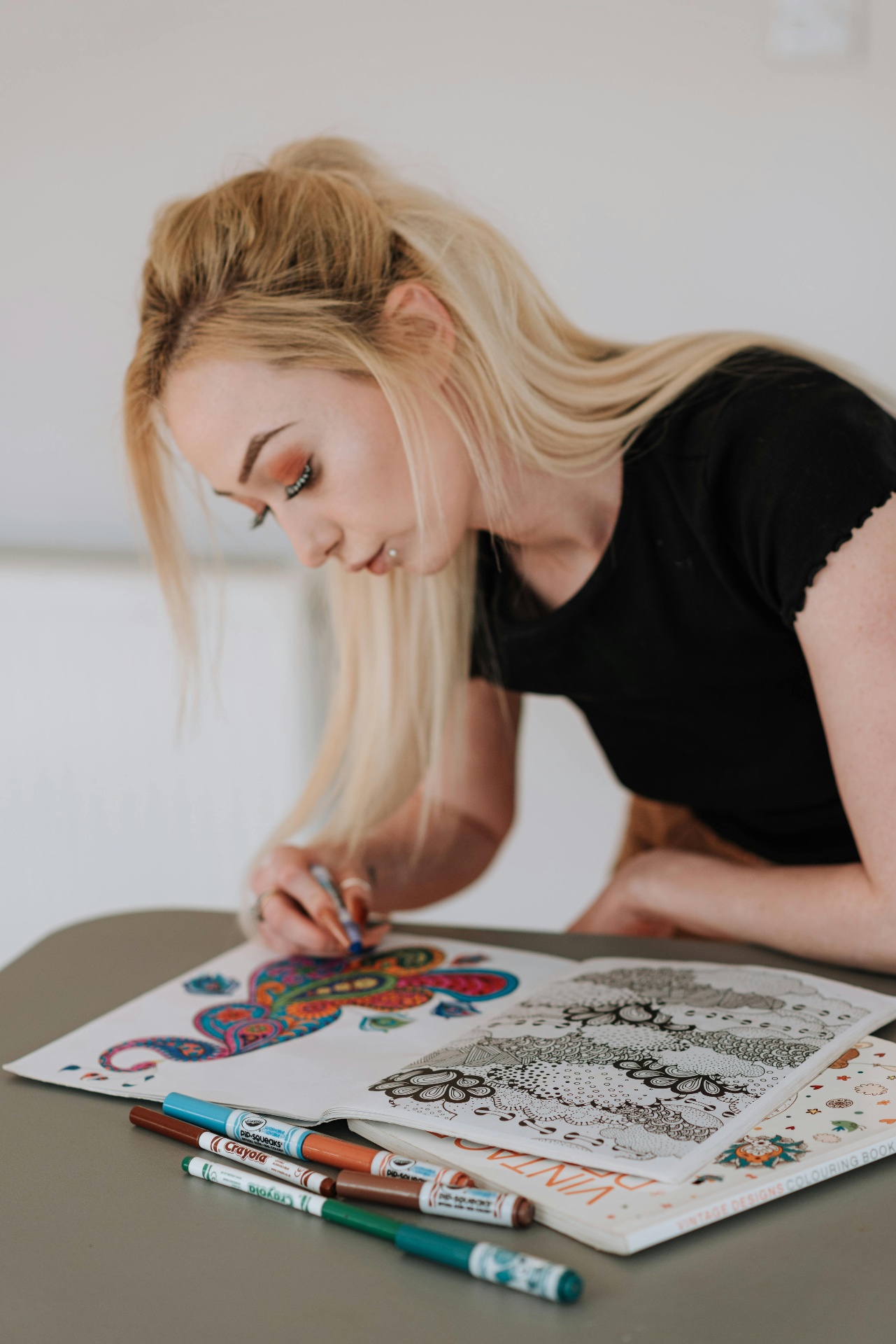 Woman focused on coloring a vibrant design in a coloring book